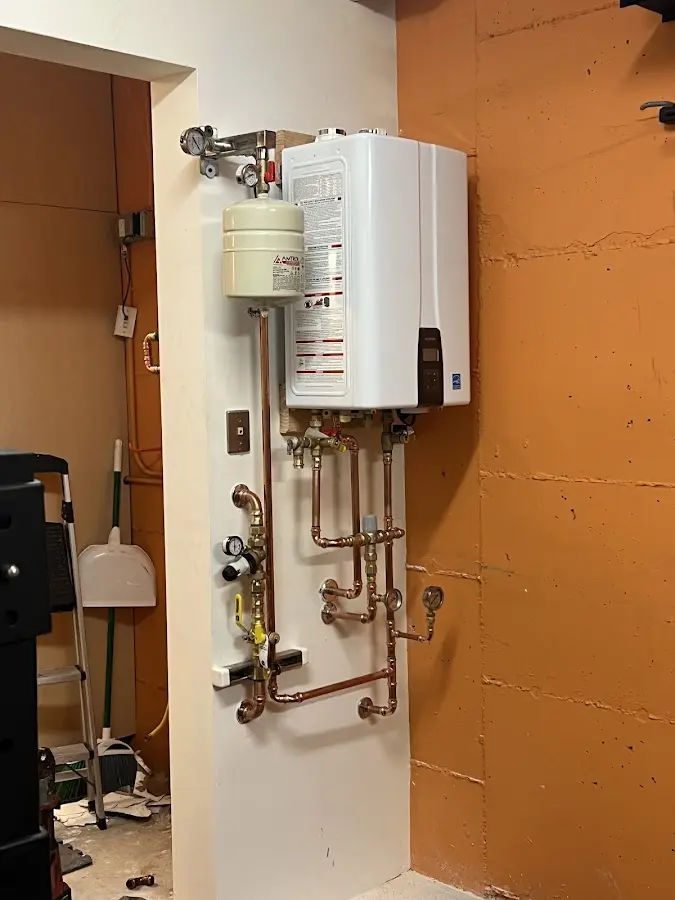Plumbing technician inspecting water heater connections in Fairland